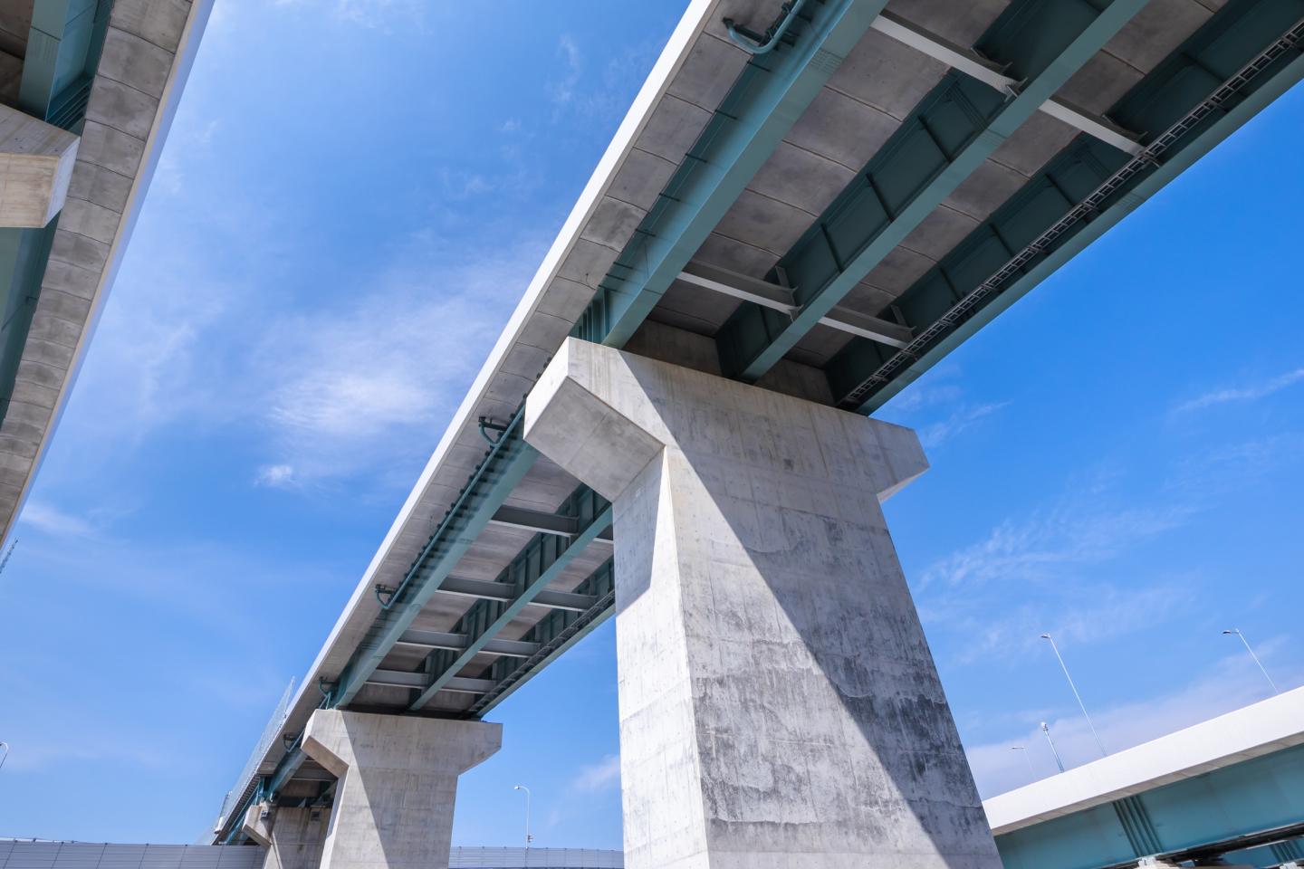 青空の下に建つ高架橋のコンクリート構造。